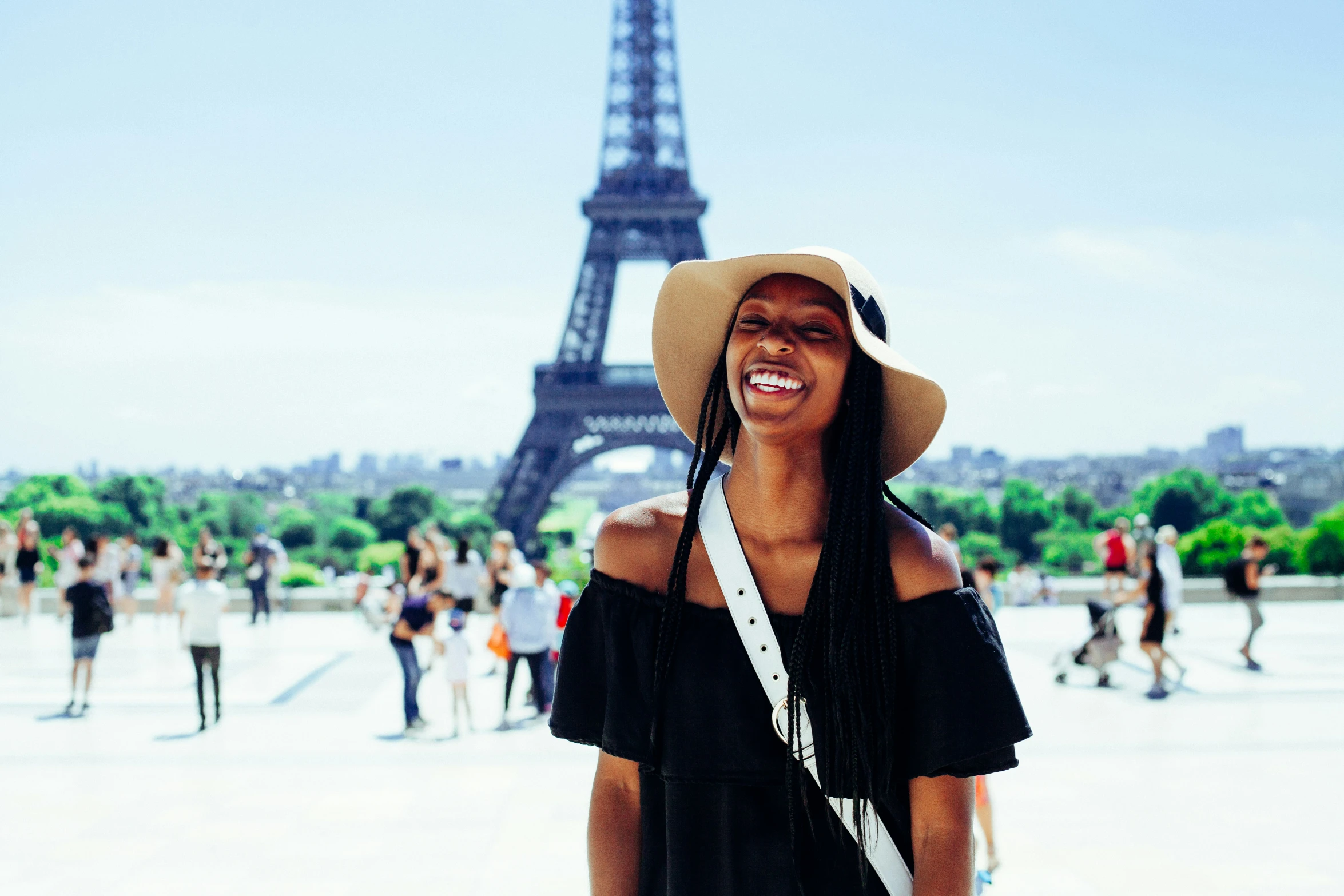 a woman is smiling in front of the eiffel tower