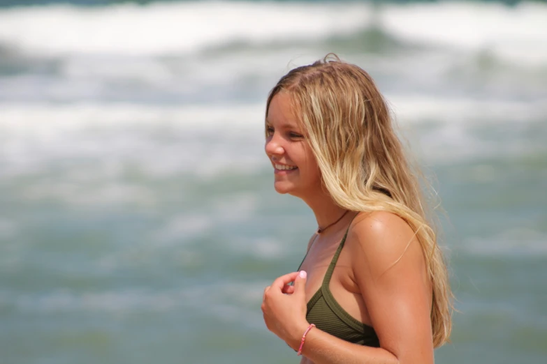 a beautiful blond woman standing on the beach