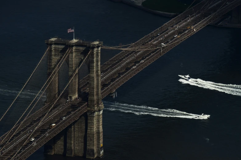 a boat passing under the bridge with a smaller boat in it