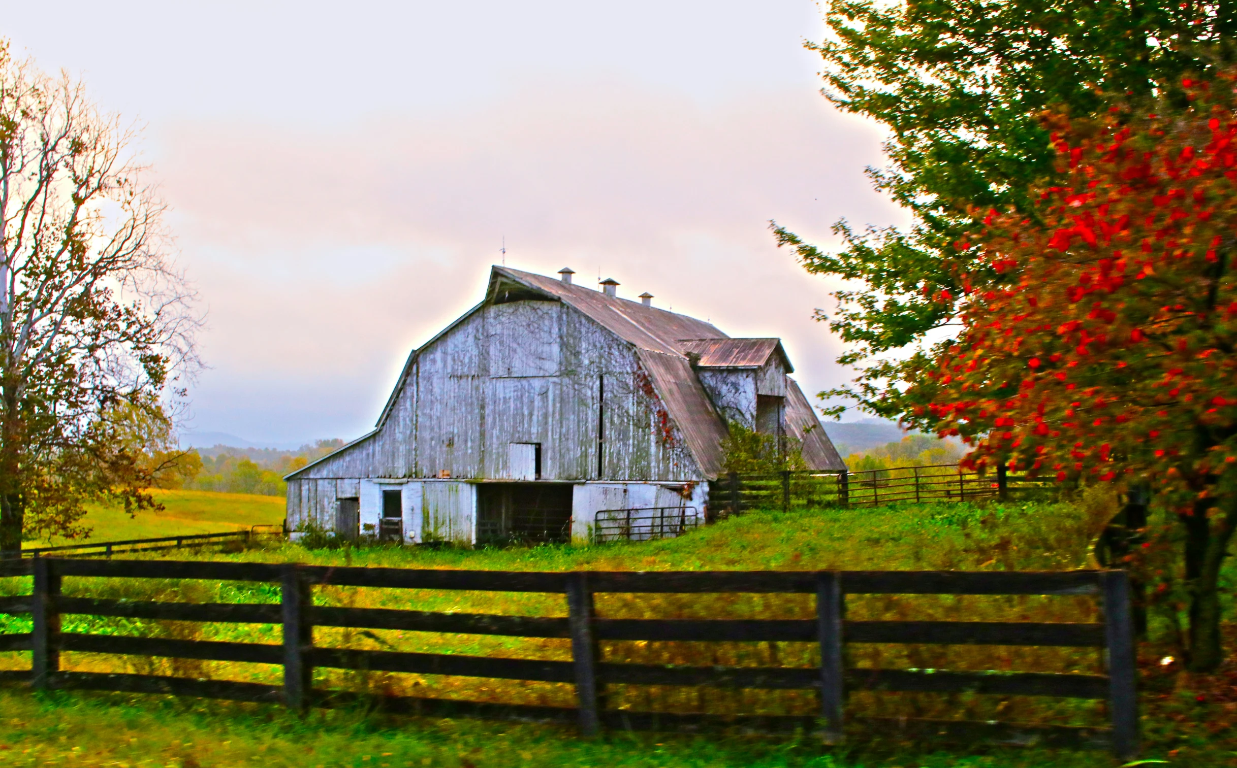 an old barn on a country farm with a large open door