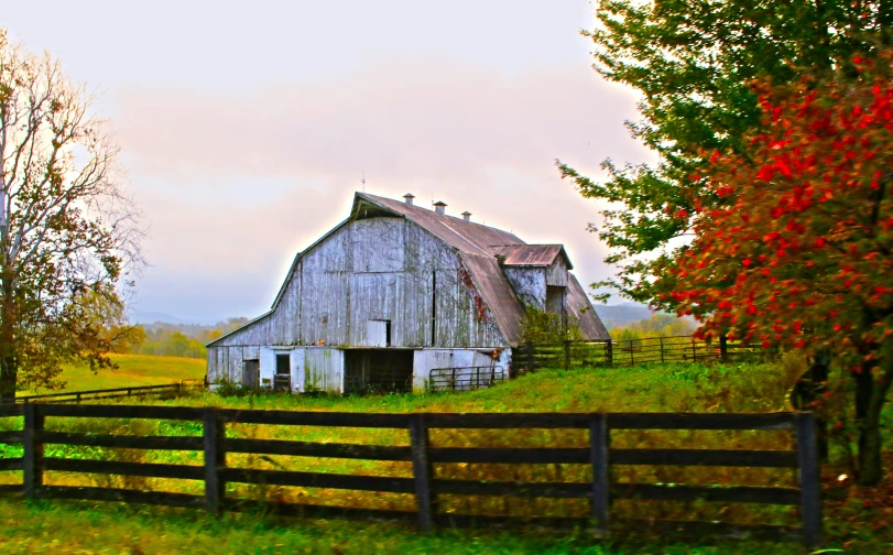 an old barn on a country farm with a large open door