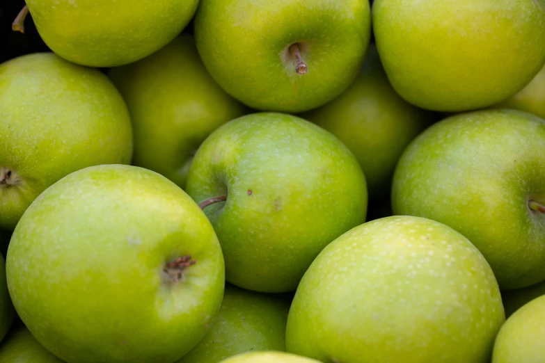 a close up of many green apples together