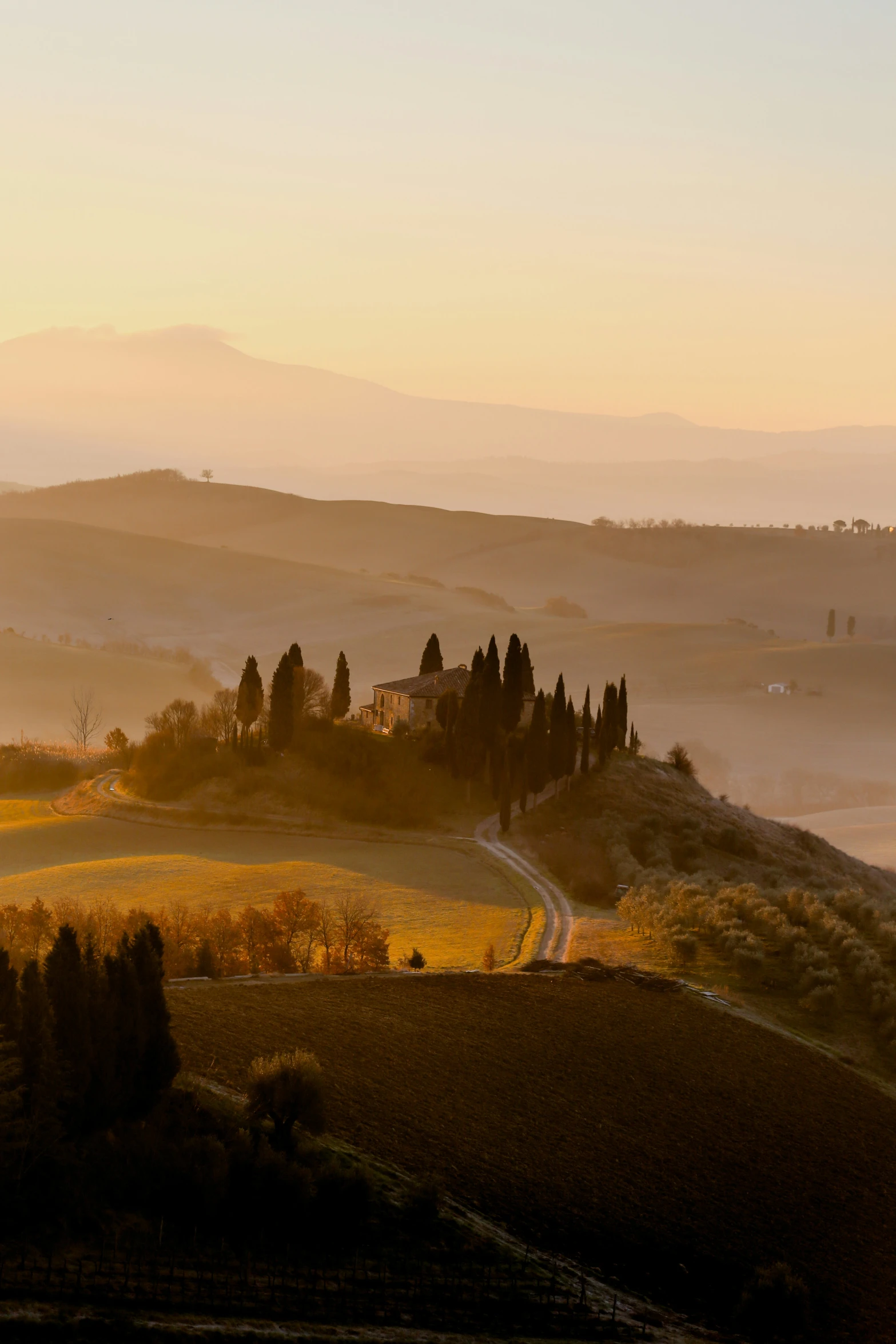 the countryside is covered in fog as the sun sets