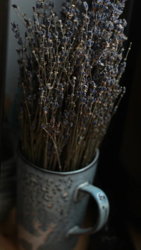 there is a grey vase with purple flowers in it