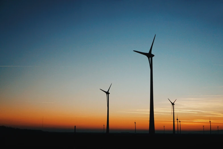 several windmills standing in the wind during the day