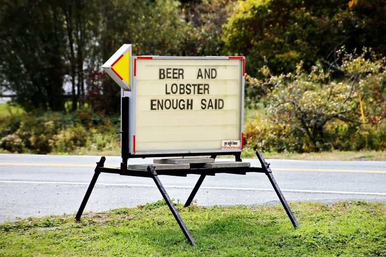 a sign that says beer and lobster enough said on the side of the road