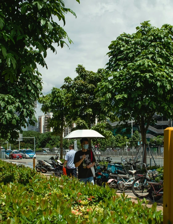 people stand outside under an umbrella near many bikes