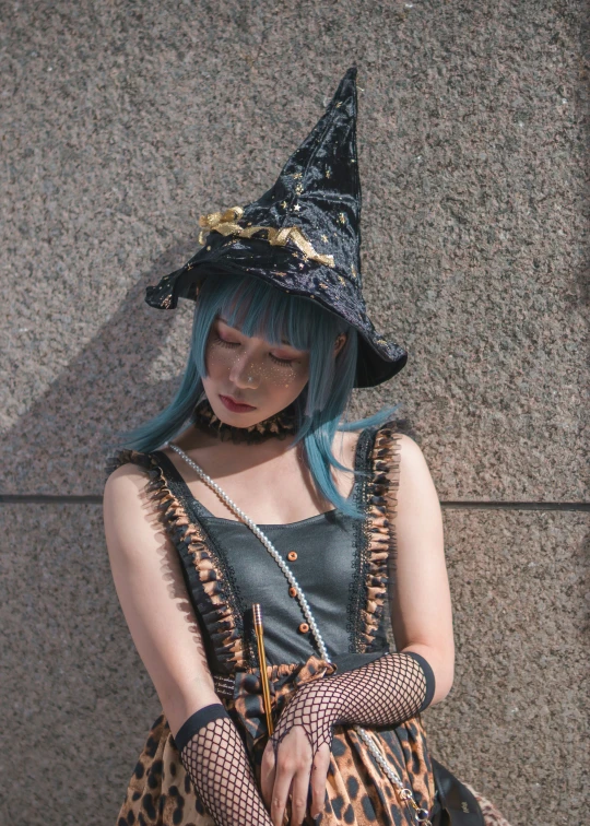 the woman with blue hair is dressed up as a witch