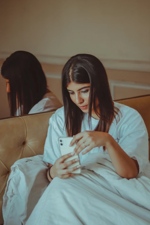 a girl sitting on her bed checking her cell phone