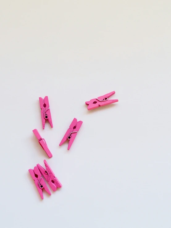 some pink clothes pegs laying on top of each other