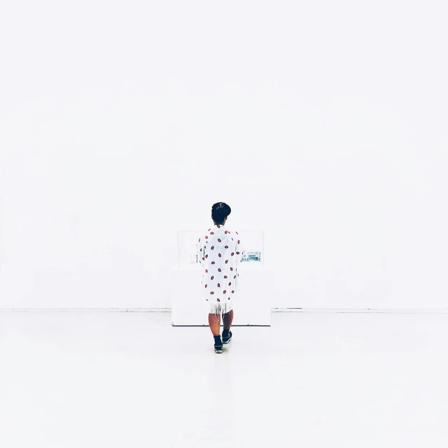 a woman in a white shirt is standing alone