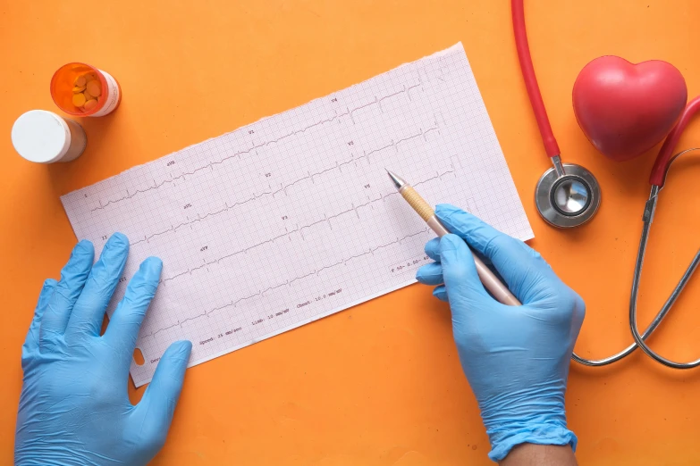 someone writing on a piece of paper with gloves on and other medical equipment on the table