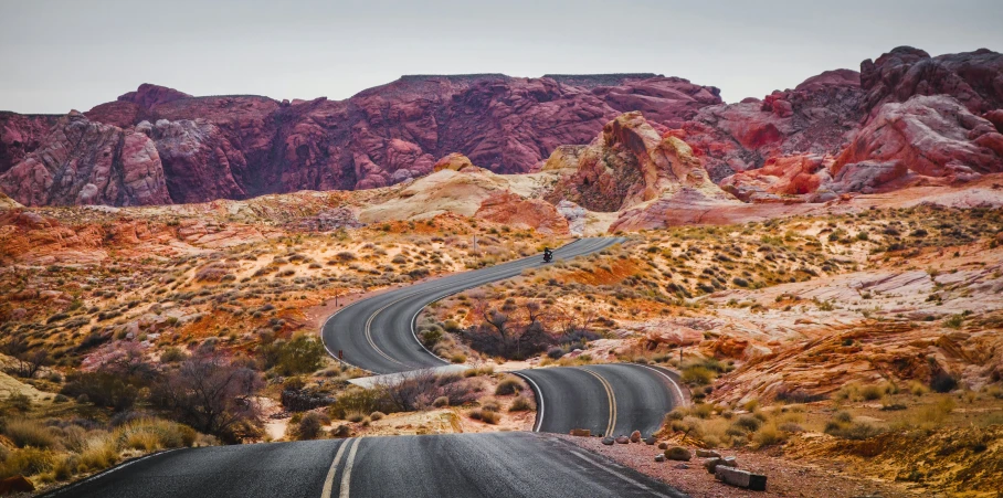 there is a very narrow, scenic road surrounded by mountains