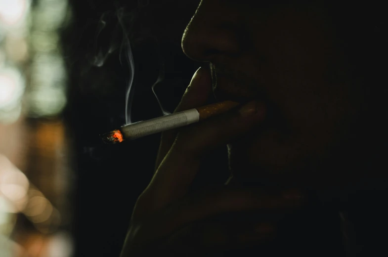 a man that is holding a cigarette in his mouth