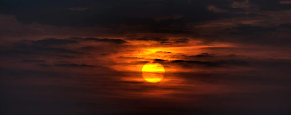 a sunset with a dark cloud in the background