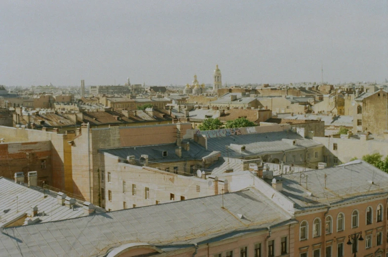 the rooftops of old buildings with a large clock tower in the background