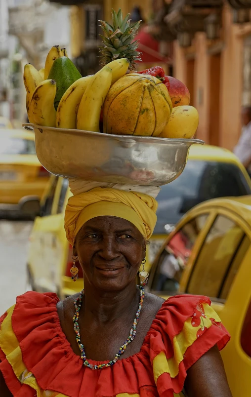 a woman standing in the street with bananas on her head