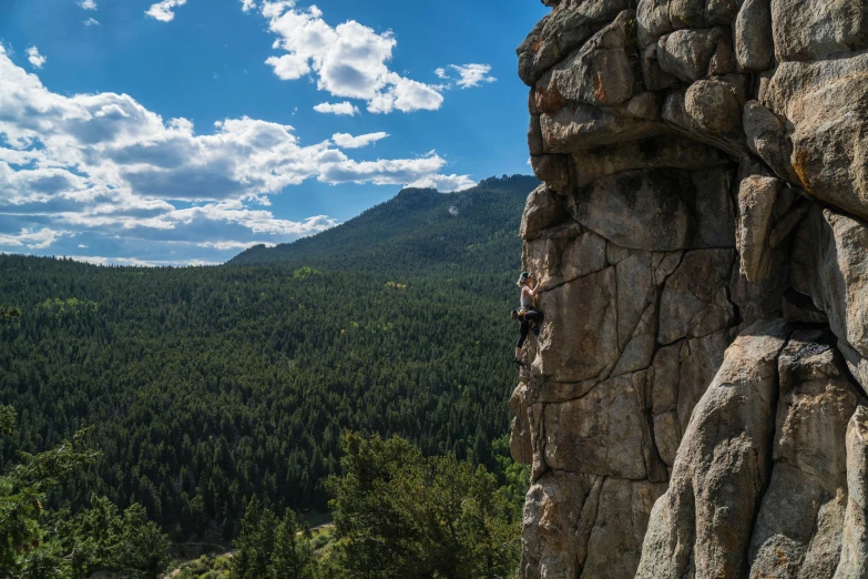 a man sitting on top of a mountain climbing