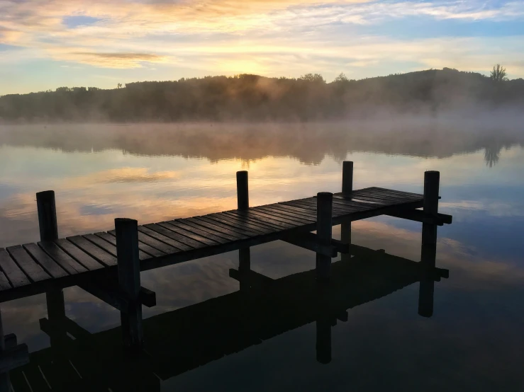 a dock sitting on top of a lake next to a body of water