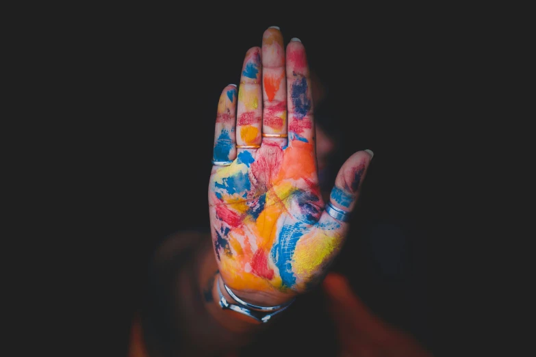 hand with colorful colors and rings painted on it