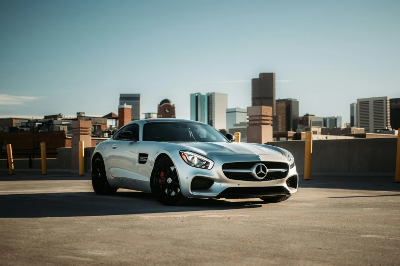 the silver and black mercedes sports car sits in front of a cityscape