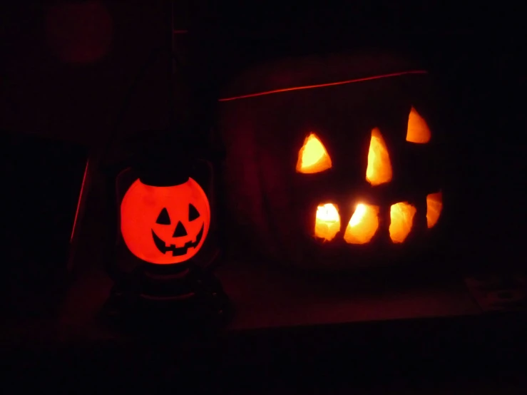 a pumpkin and a jack - o - lantern glowing at night