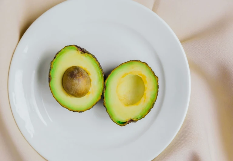 two pieces of avocado sitting on top of a white plate