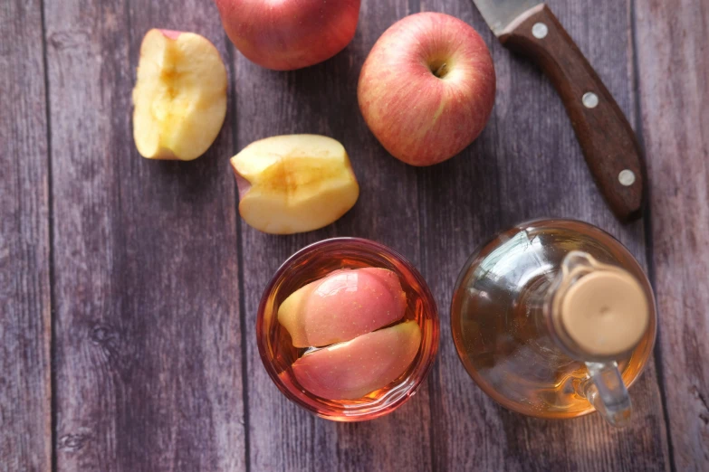 fruit on wooden table with glasses, knife and jar