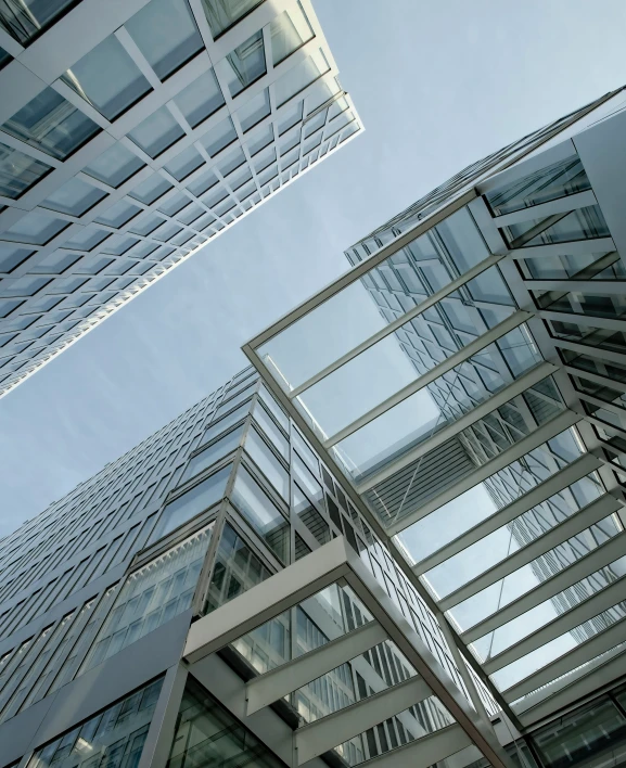 looking up at the sky at the glass facade of a building