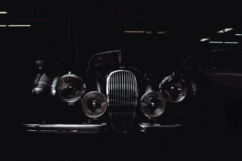 the front of a classic car in the dark