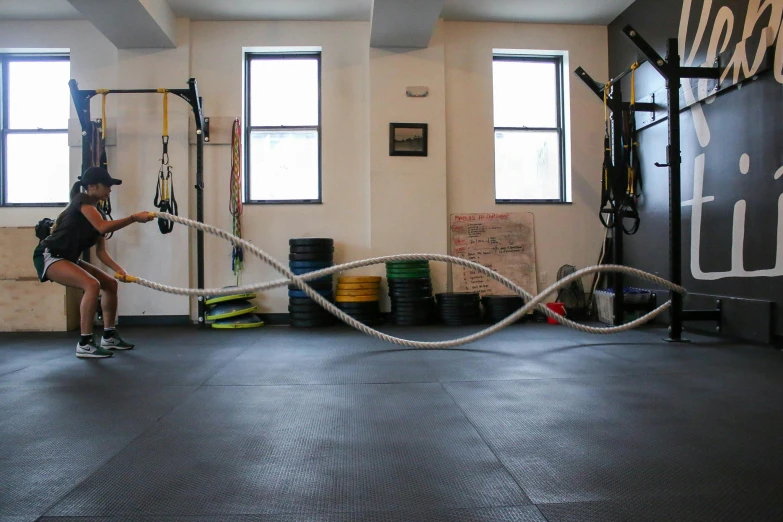 a woman lifting a rope around a gym