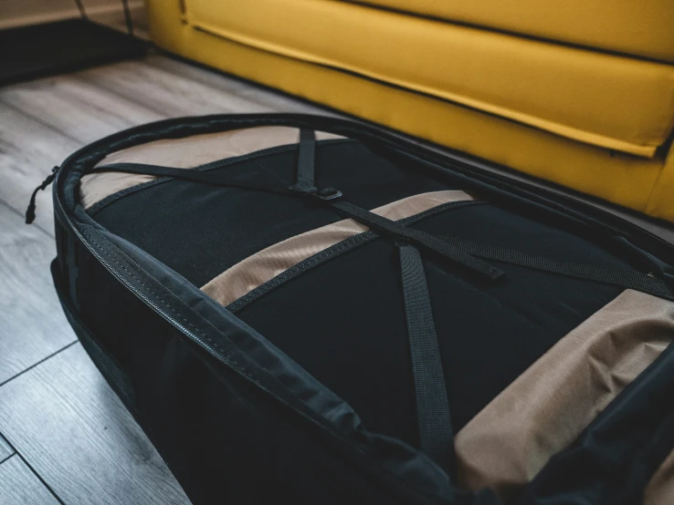 an open suitcase sitting on the ground by a yellow couch