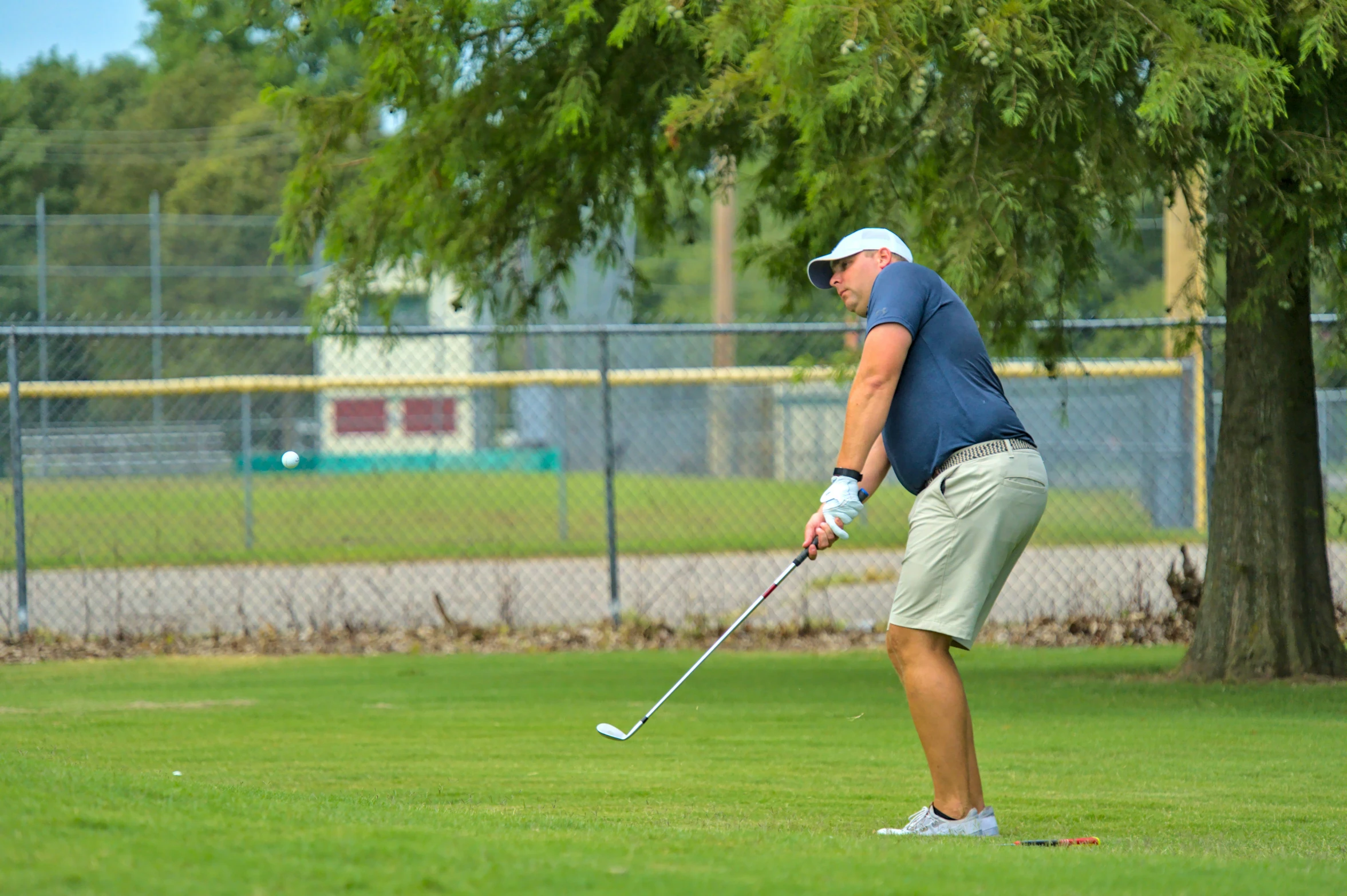 a man swinging his golf club on the grass