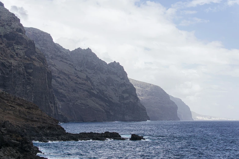 an ocean scene shows the ocean and a mountain