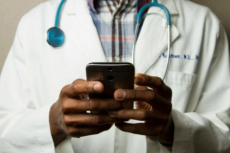 a doctor holding up a smart phone in his hand