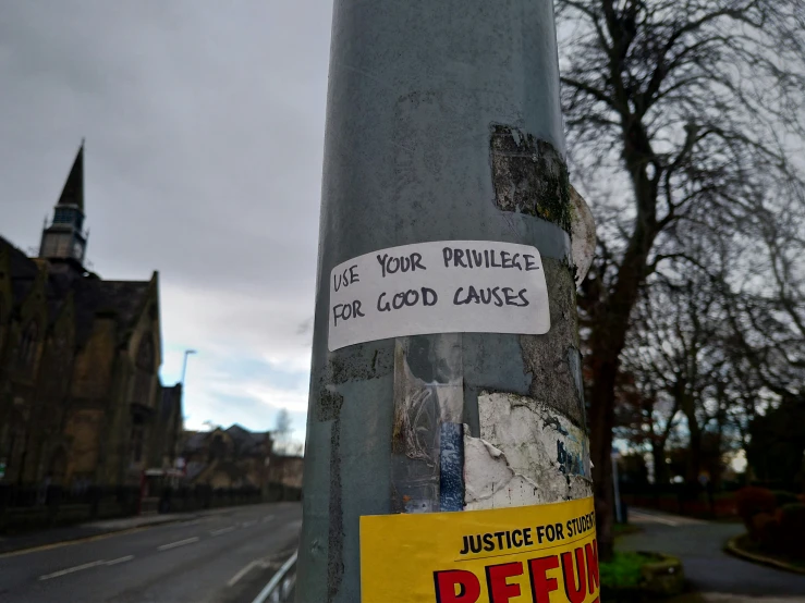stickers are taped on the street pole next to a church