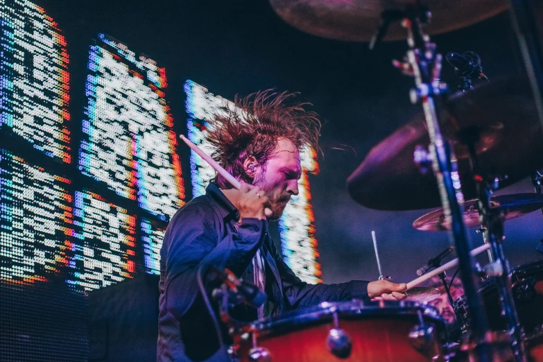 the rock drummer with long hair plays drums