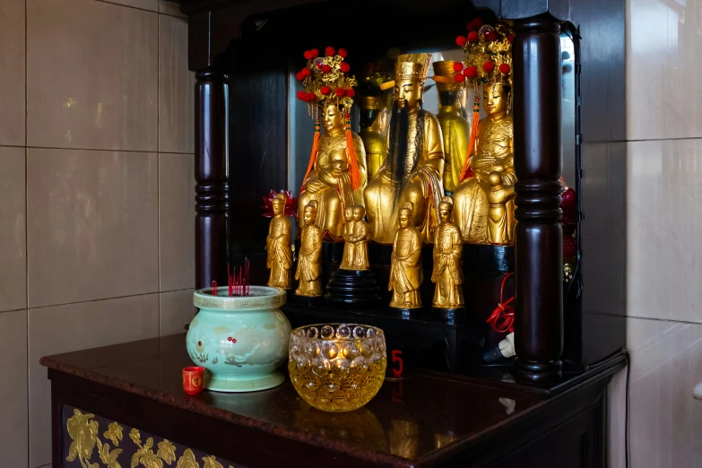 a shrine scene with three golden buddhist monks