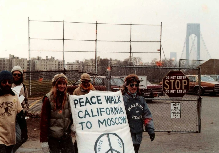 a group of people holding signs near some gates