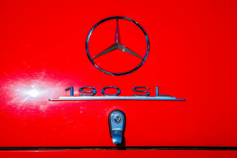 a mercedes emblem on the front door of a red car