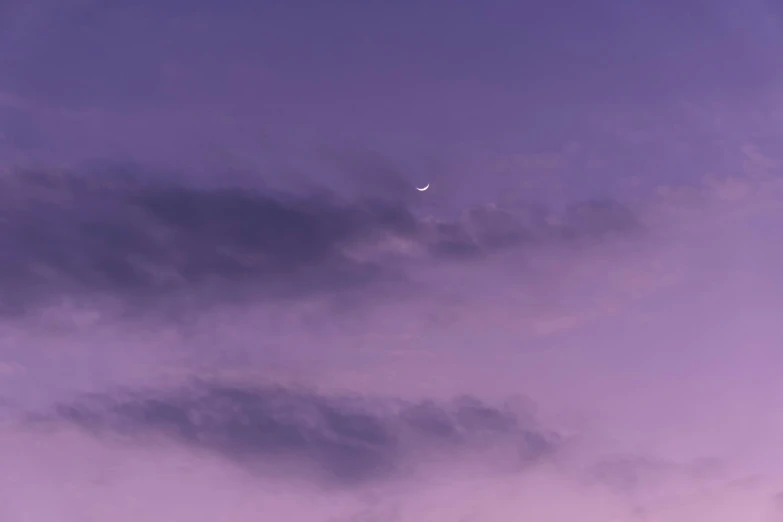 a bright purple cloudy sky with an airplane