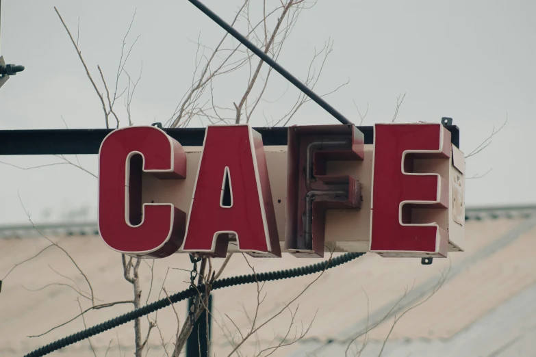 a sign that says cafe is hanging from a metal pole