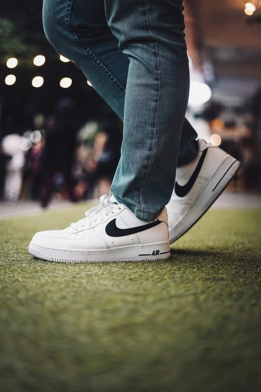 a white nike sneaker with blue jeans