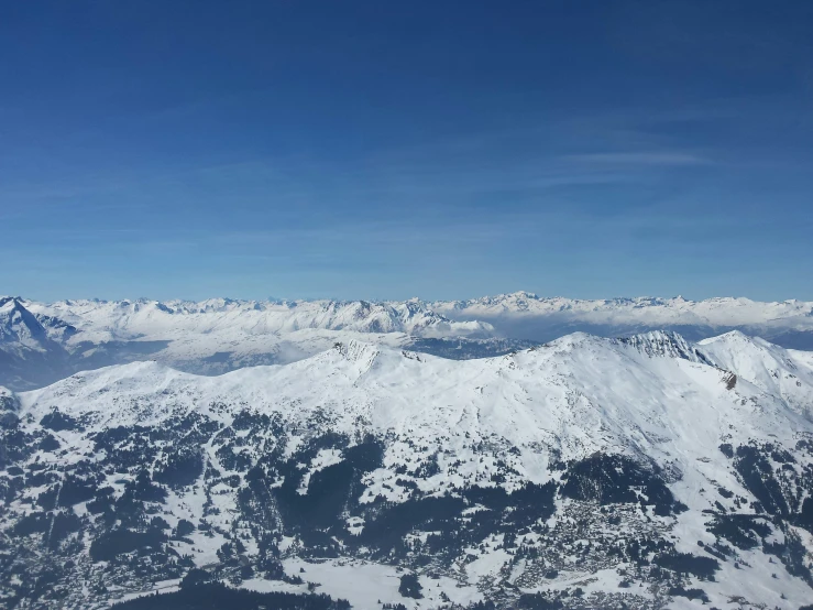 a snowy mountain range with hills below