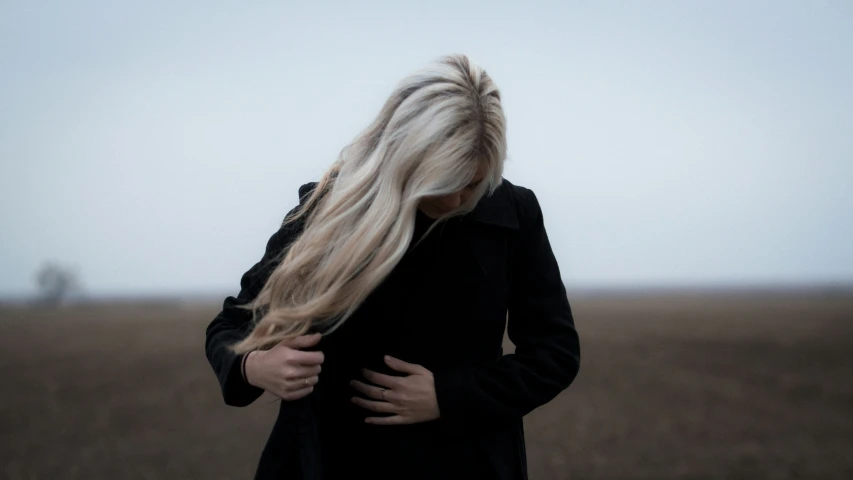 a blonde woman with long hair in a field