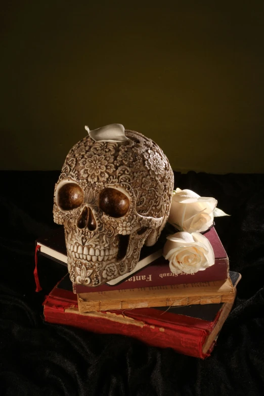 skull on two books with white flowers and candle