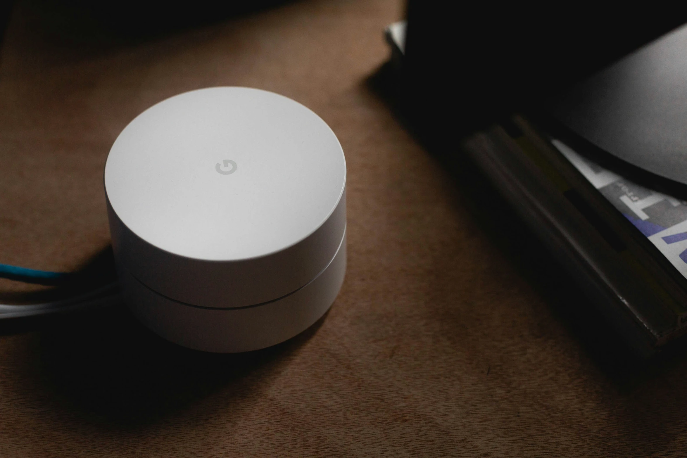 a white google wifi device sitting on a brown table