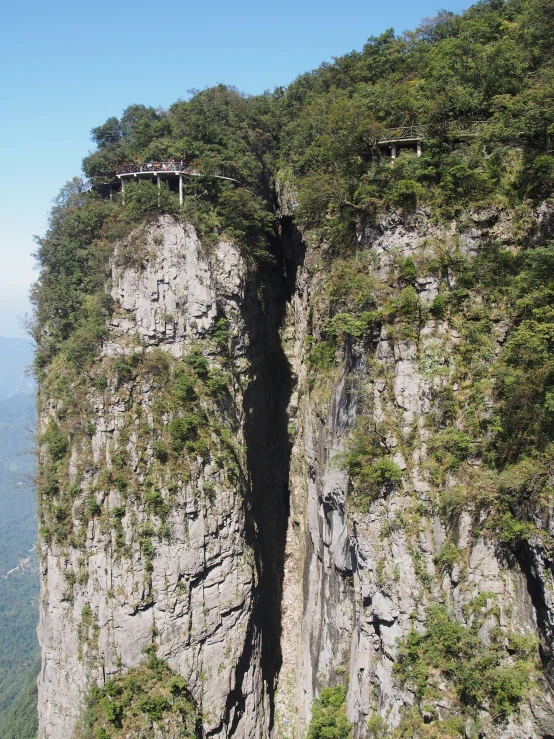 a view of a large narrow cliff and some grass