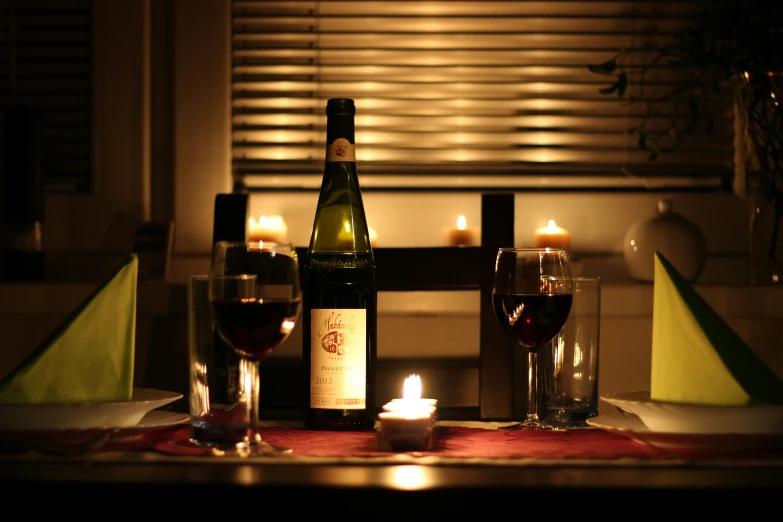 the table is set up with candles and wine bottles