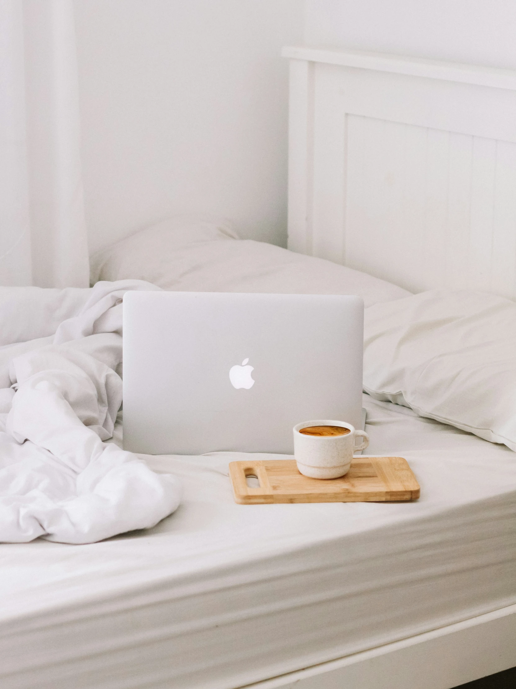 a cup of coffee on top of a white bed